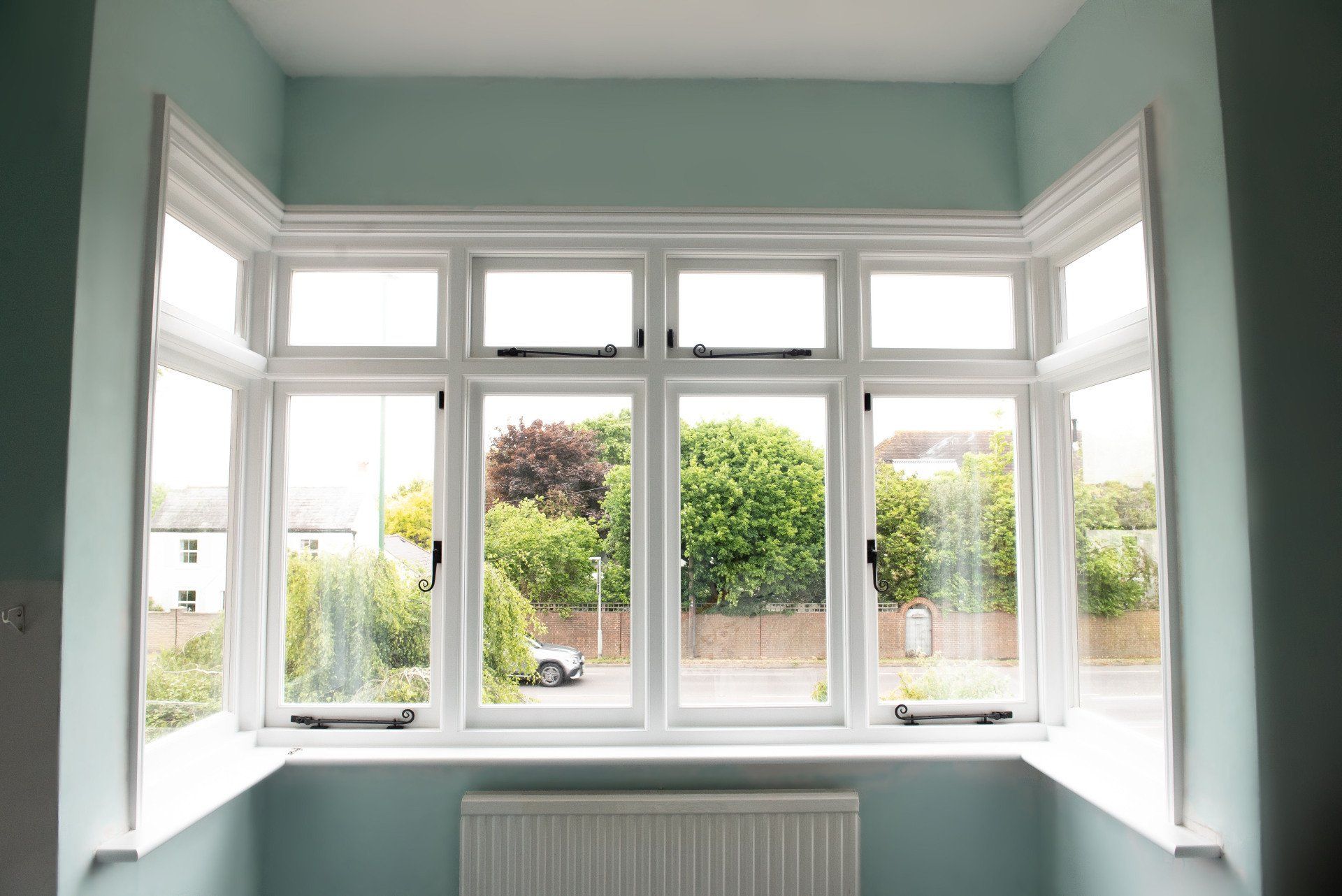 Bright airy view of casement bay windows looking out the front of the house