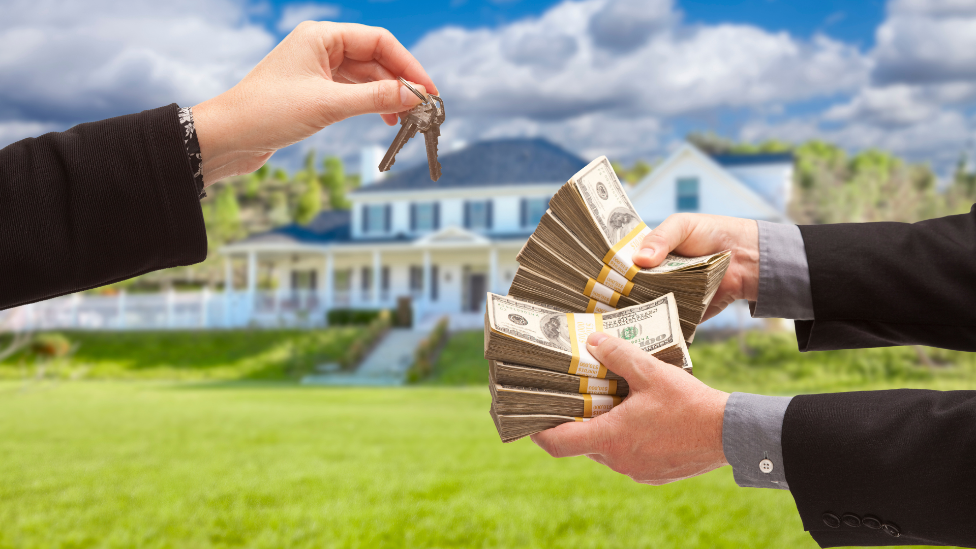A man is handing a stack of money to another man in front of a house.