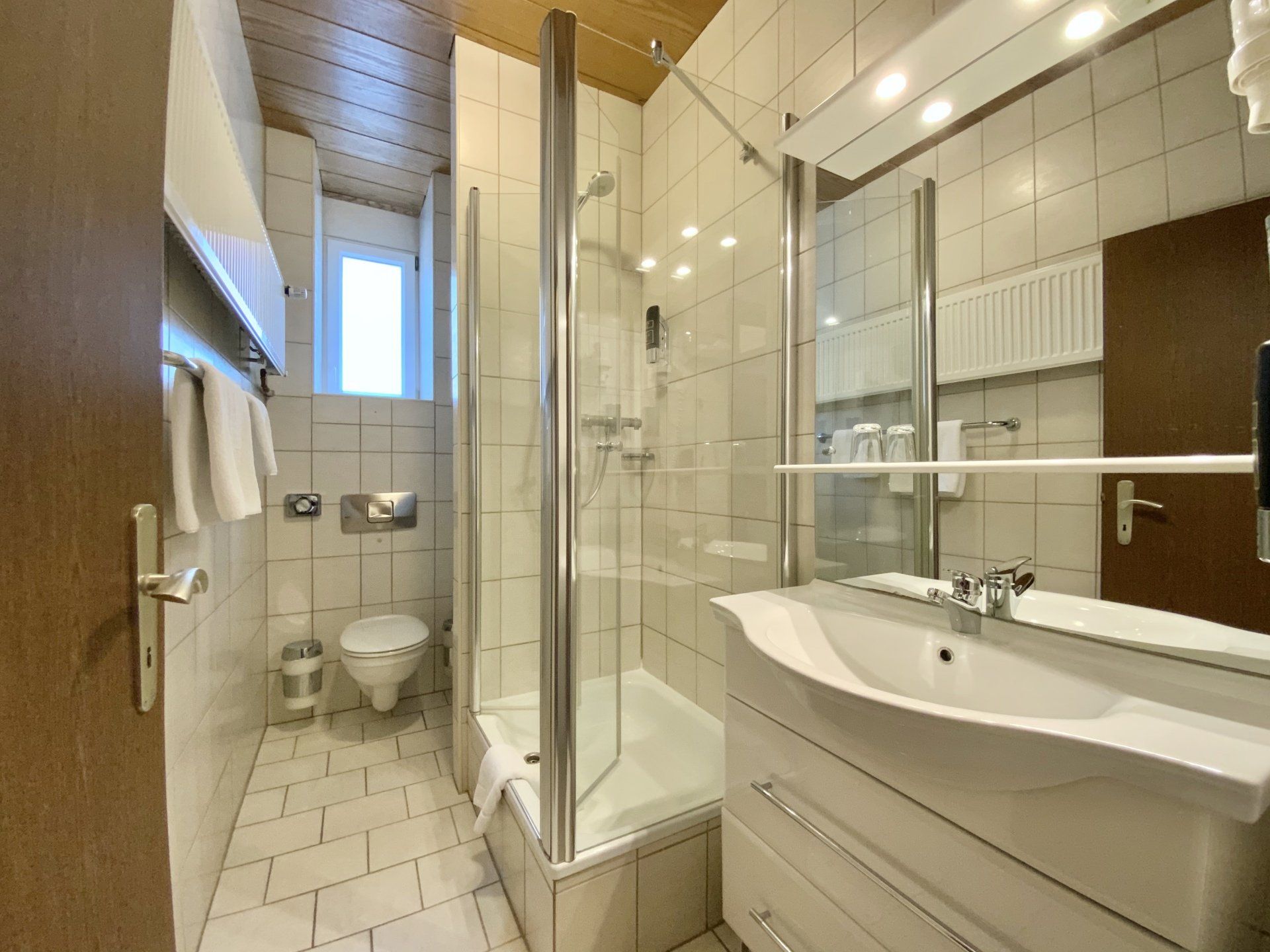 Ein Badezimmer mit Waschbecken, Toilette, Dusche und Spiegel.