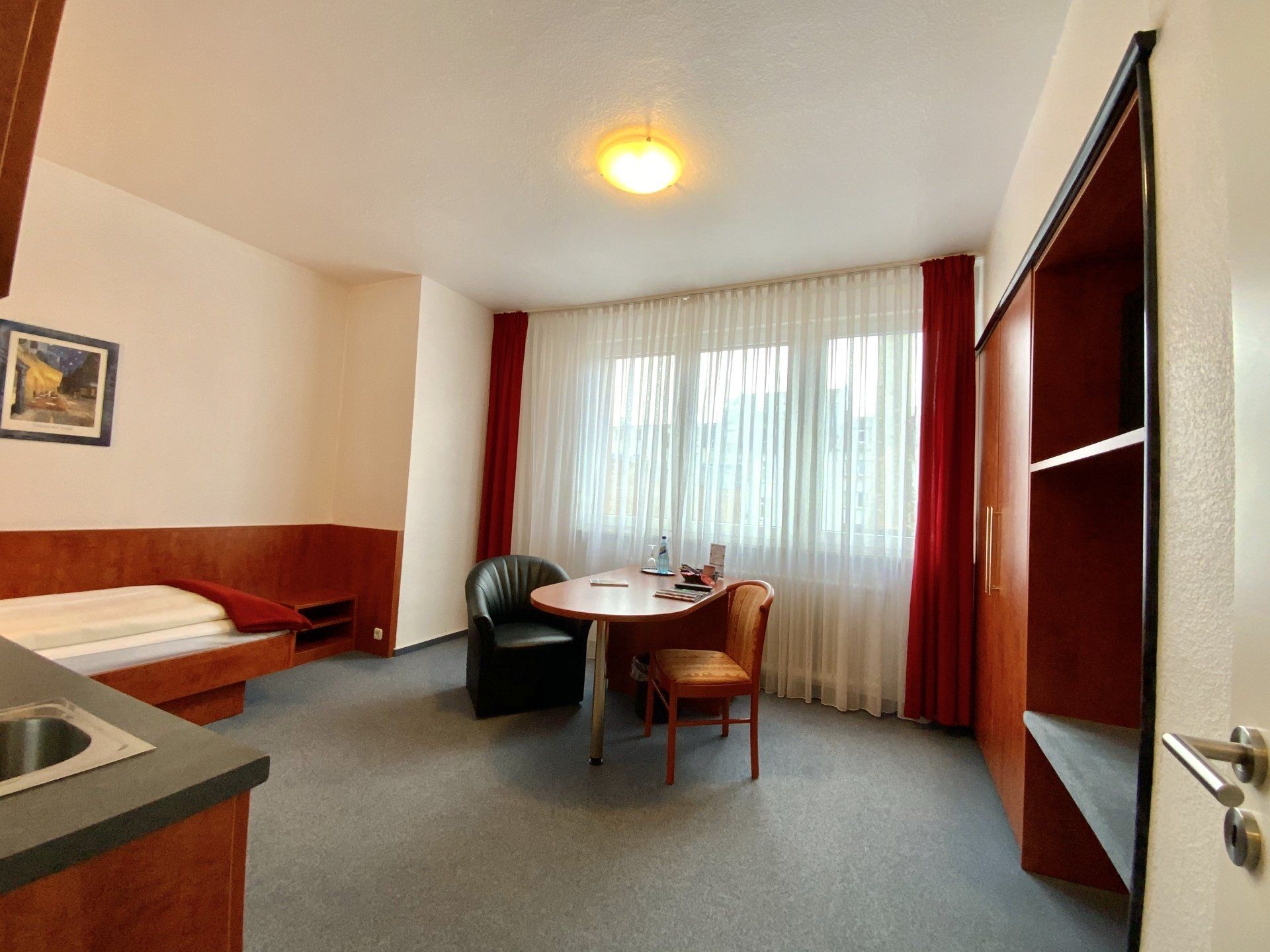 Ein Hotelzimmer mit einem Tisch und Stühlen und einem Bett