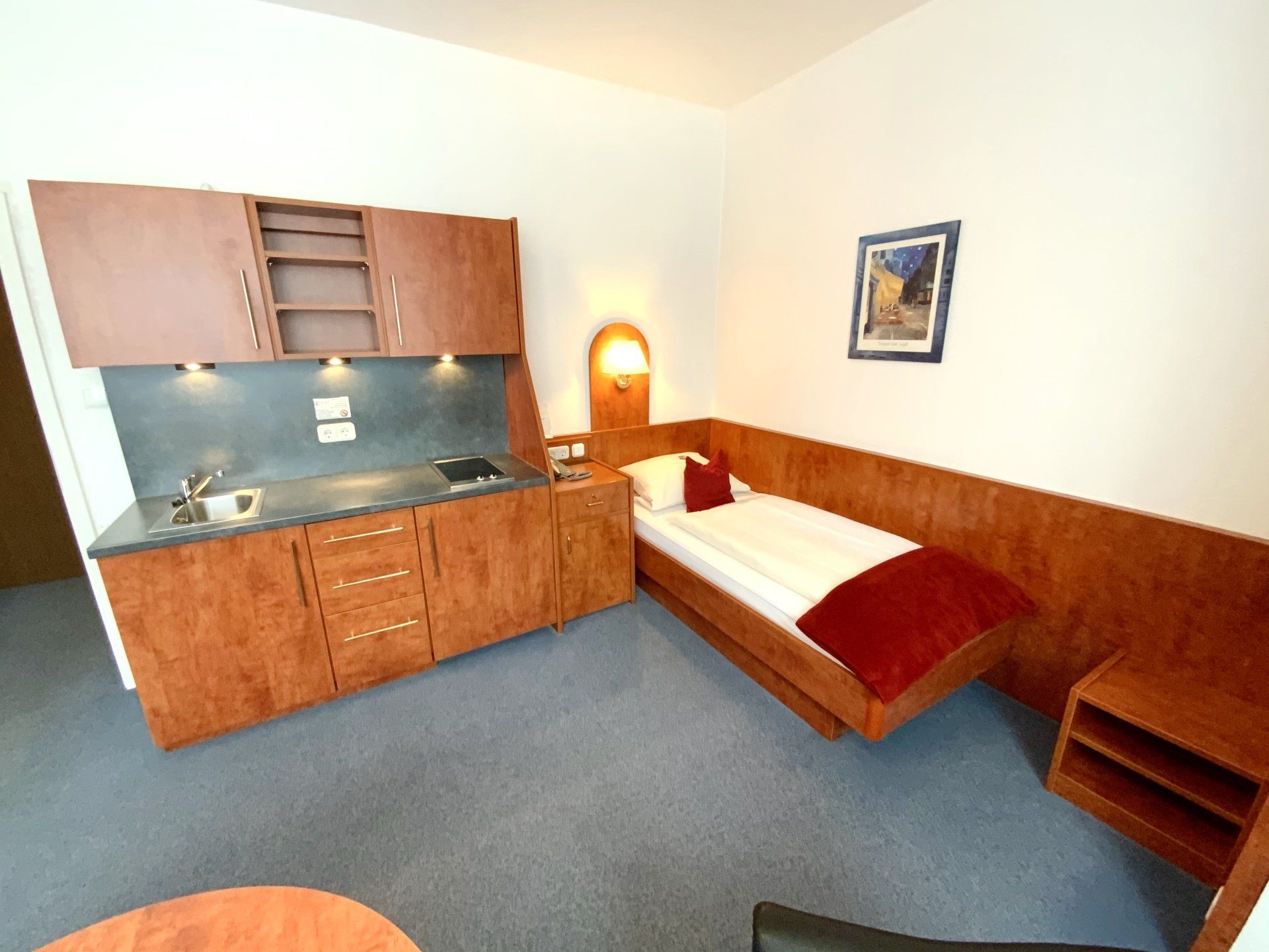 Ein Hotelzimmer mit Einzelbett und Küche