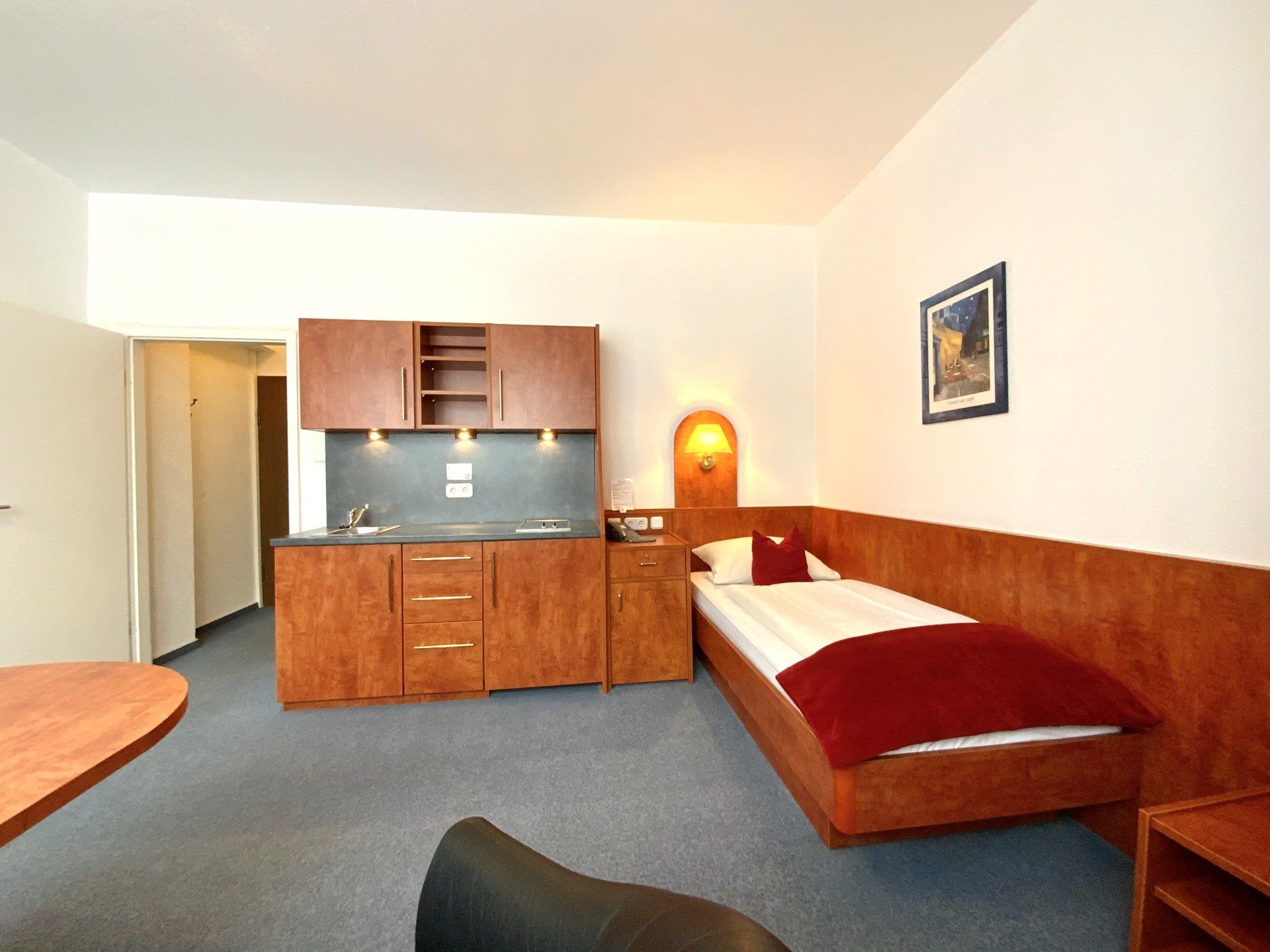 Ein Hotelzimmer mit Einzelbett und Küche