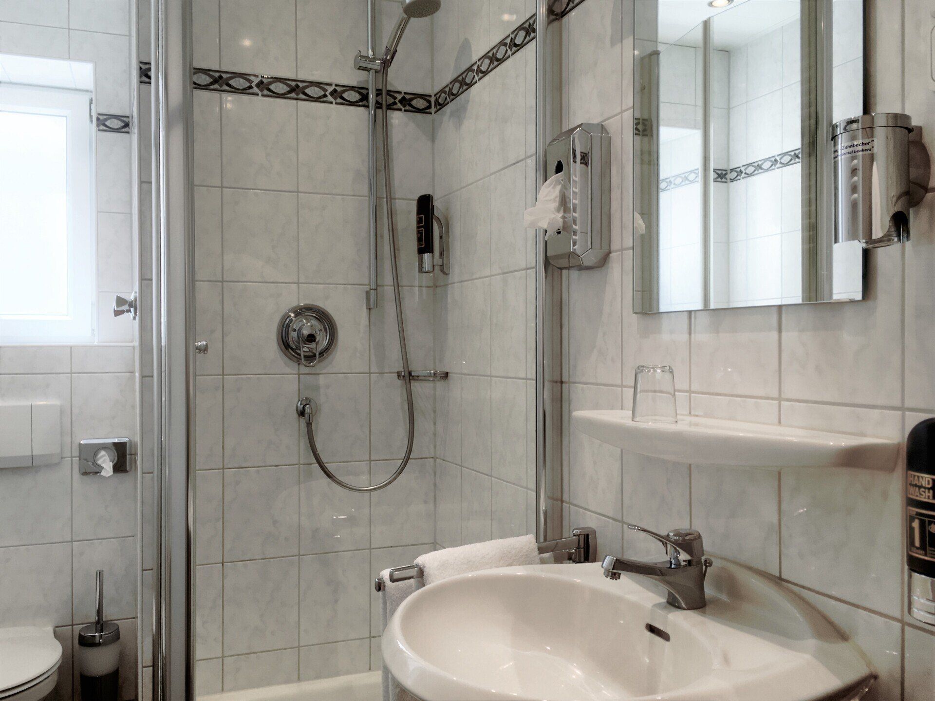 A bathroom with a sink a toilet and a shower