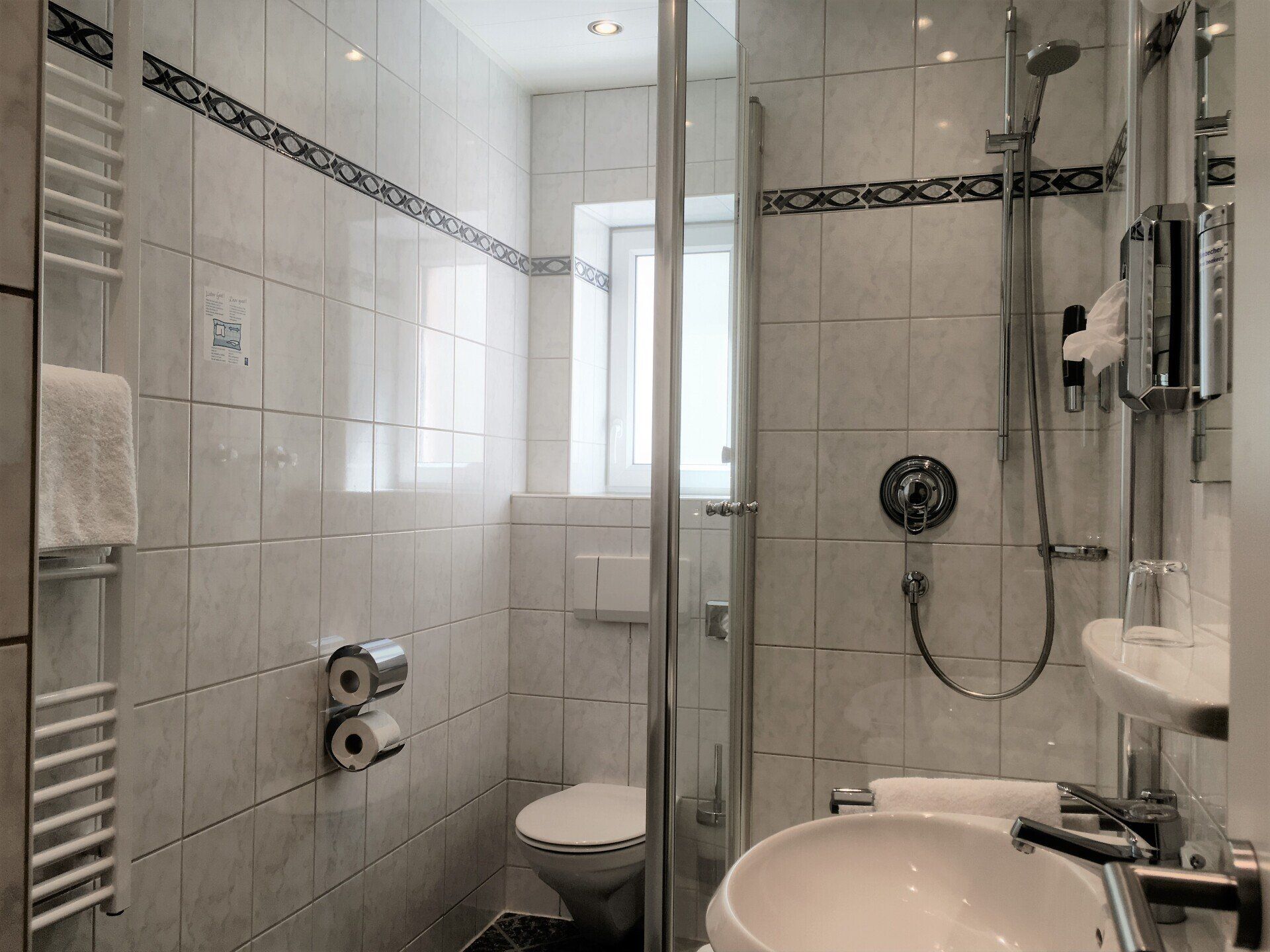 A bathroom with a toilet , sink , and shower.