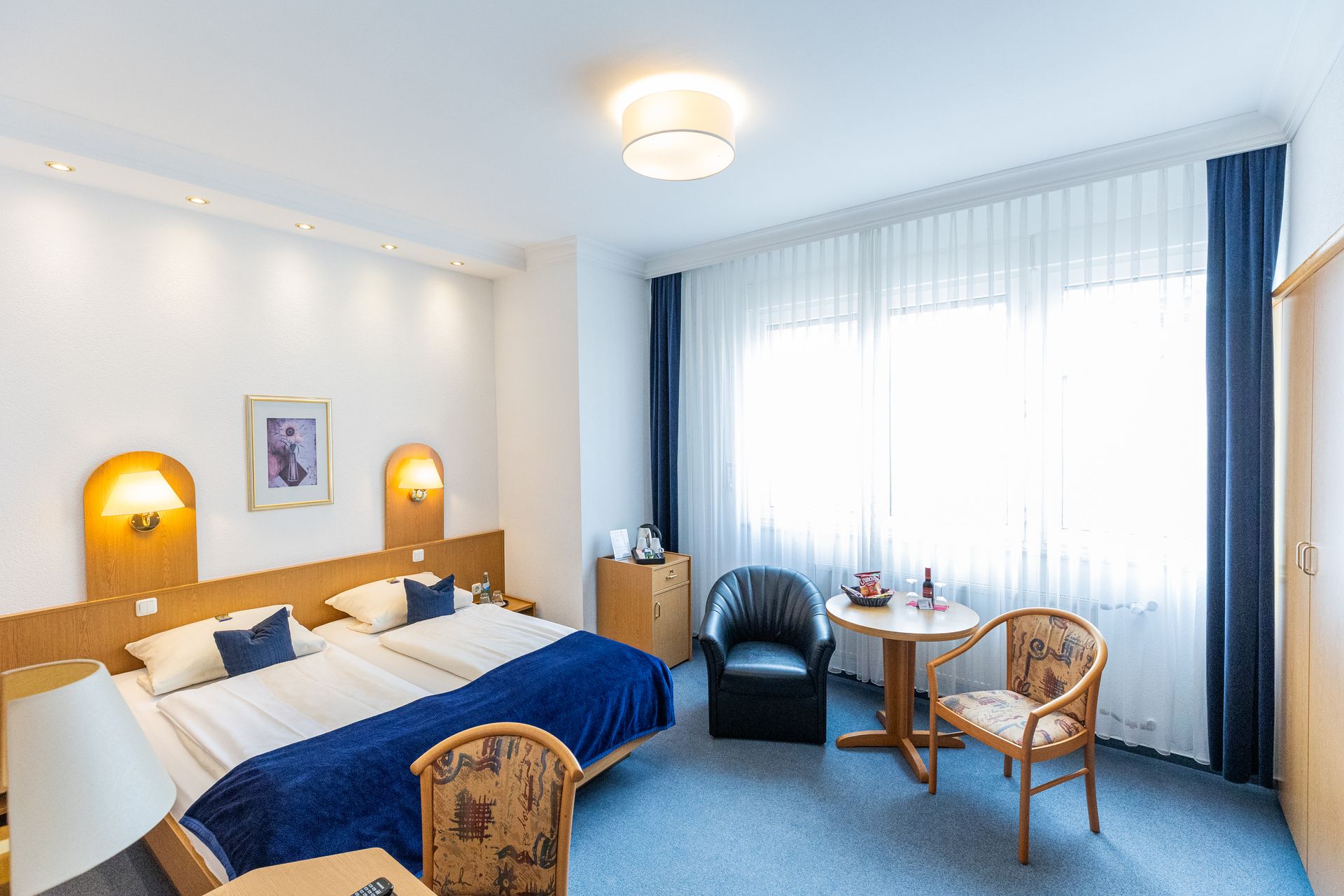 Ein Hotelzimmer mit einem großen Bett und einem Stuhl