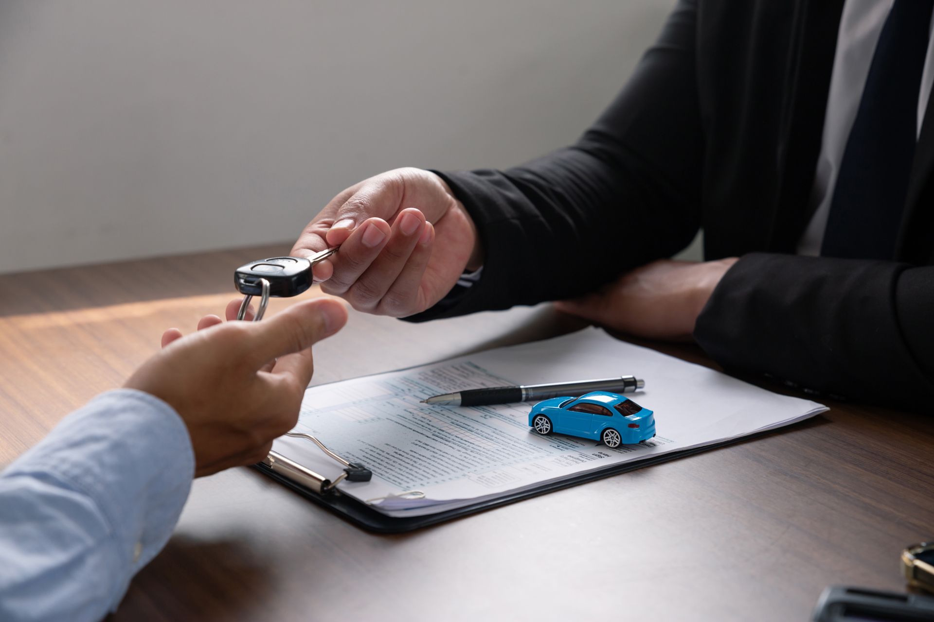 A Man is Giving a Car Key to Another Man