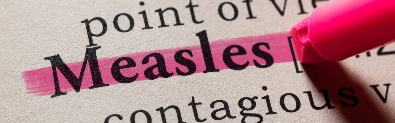 The word Measles is highlighted pink in a textbook