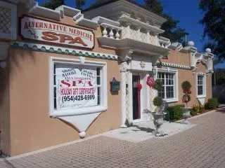 Storefront for “Alternative Medicine Spa” with a white sign and peach stucco facade.
