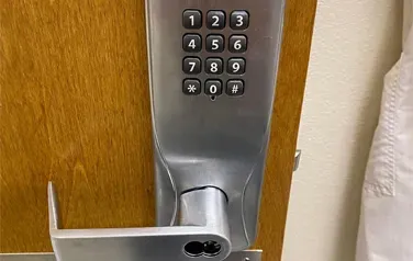 A close up of a door lock with a keypad on it.