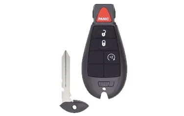 A remote control with a key attached to it on a white background.