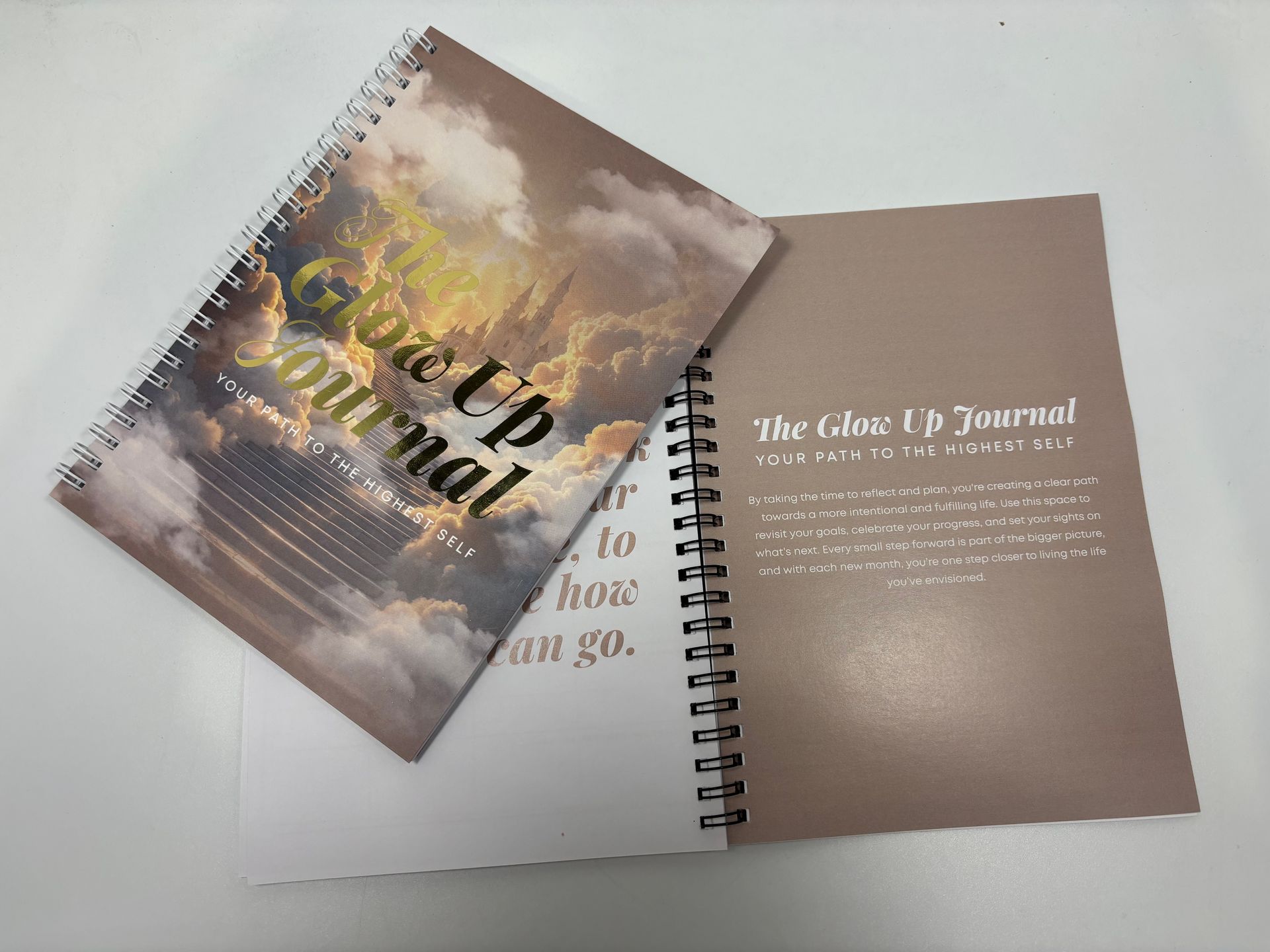 A spiral notebook with a picture of a cloudy sky on the cover.