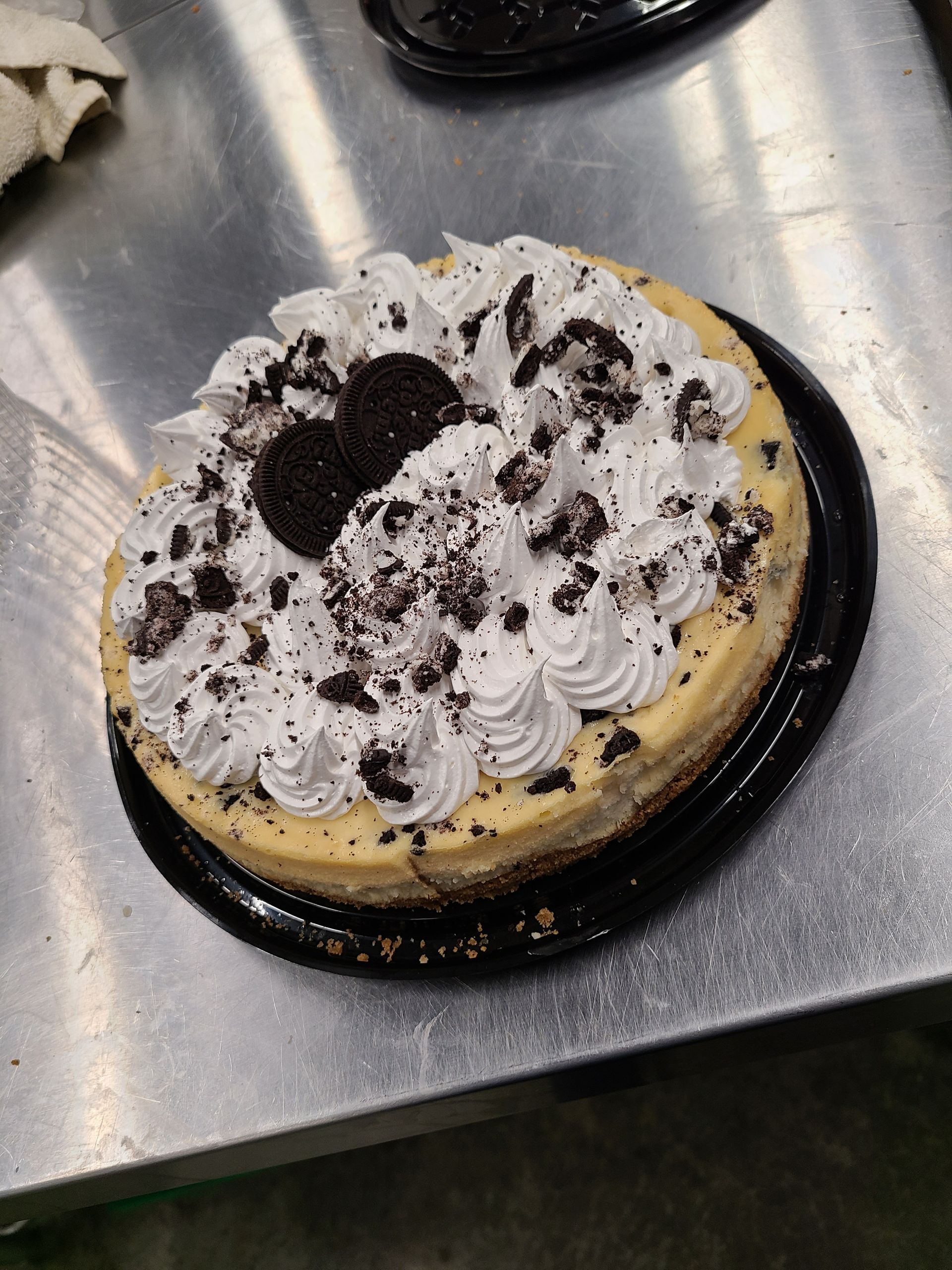 A cheesecake with oreos and whipped cream on top