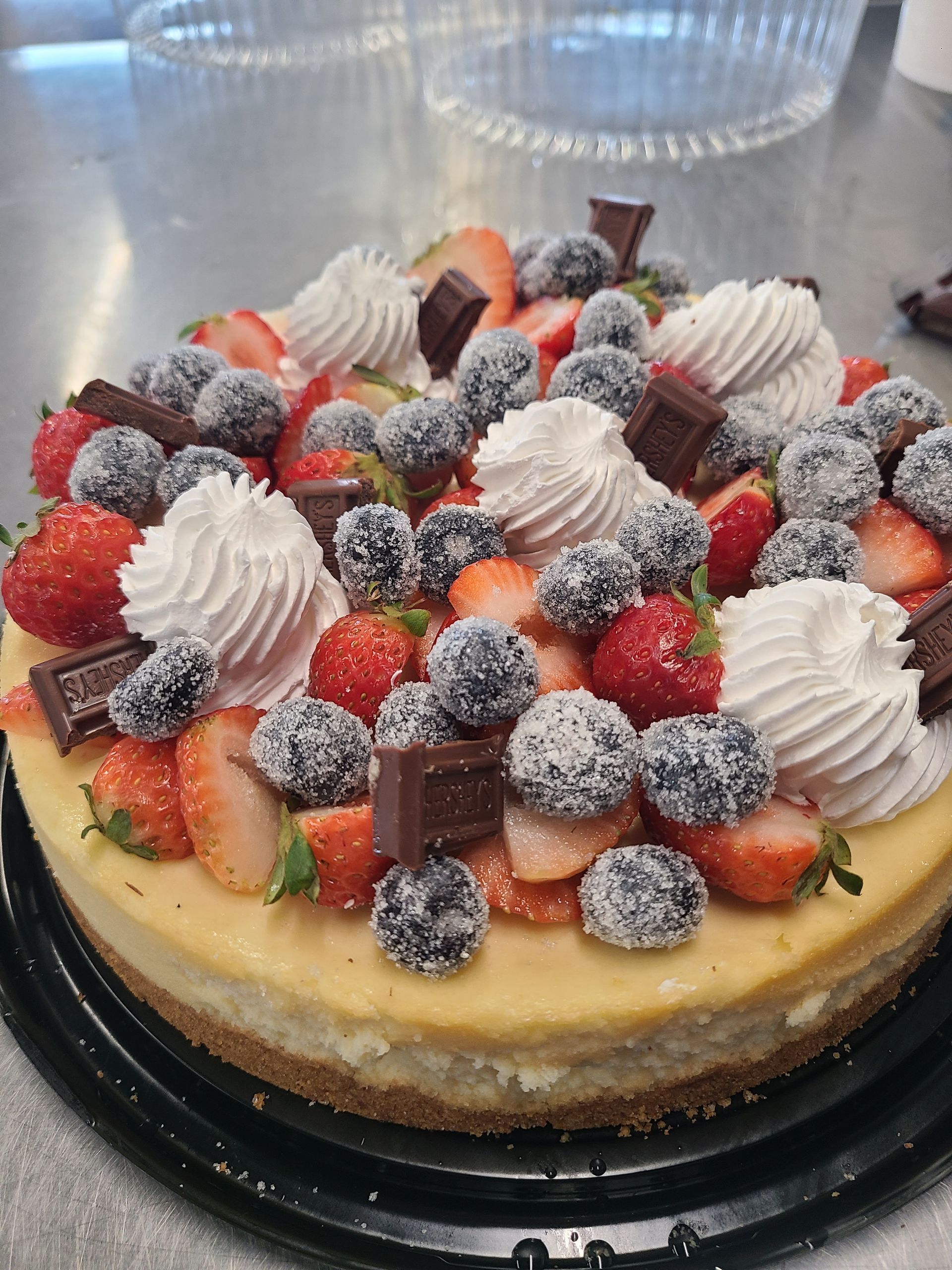 A cheesecake with whipped cream strawberries and blueberries on top