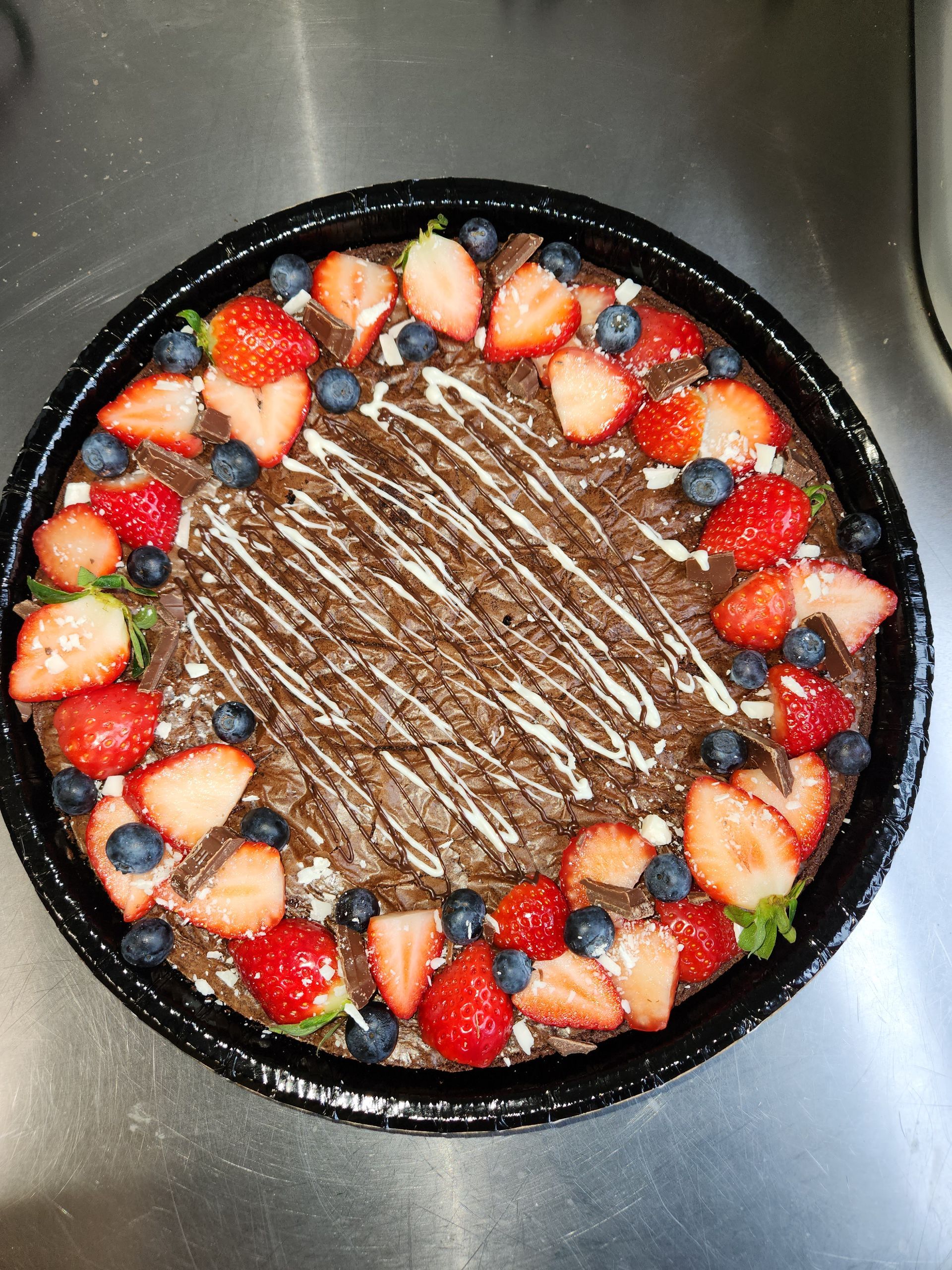 A pizza with strawberries and blueberries on top of it