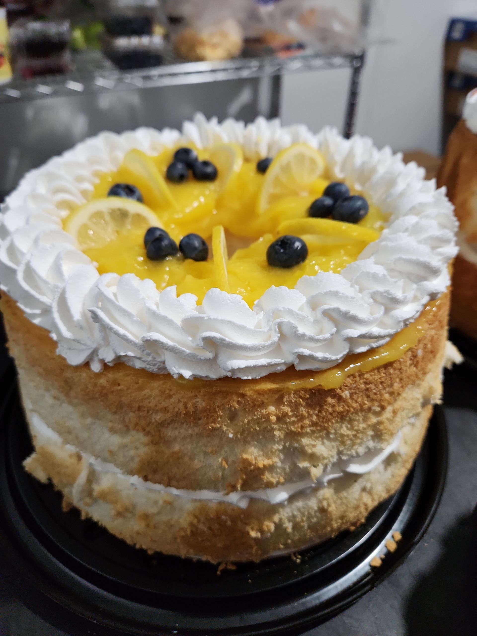 A cake with lemons and blueberries on top of it