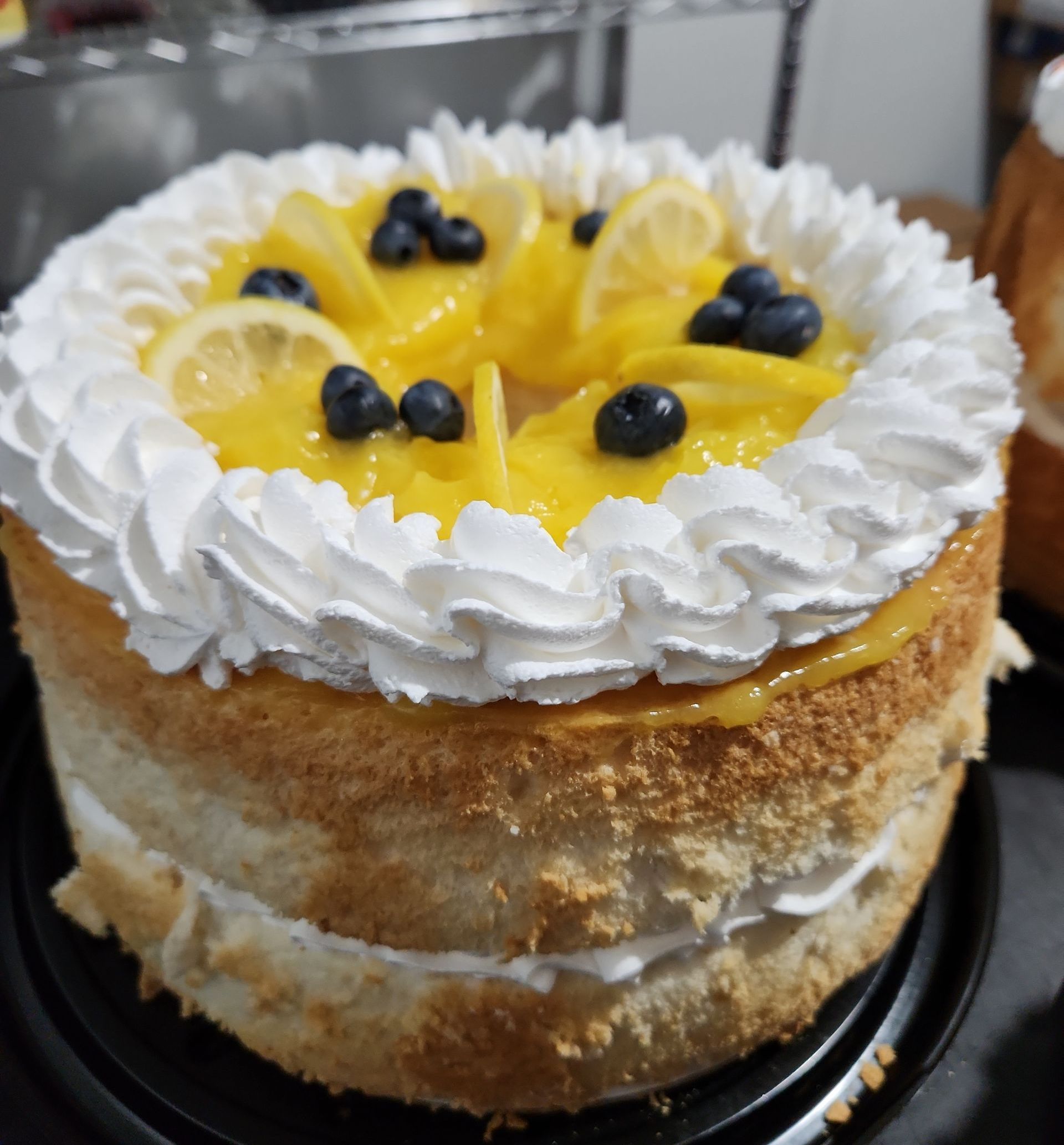 A cake with whipped cream and lemon slices on top