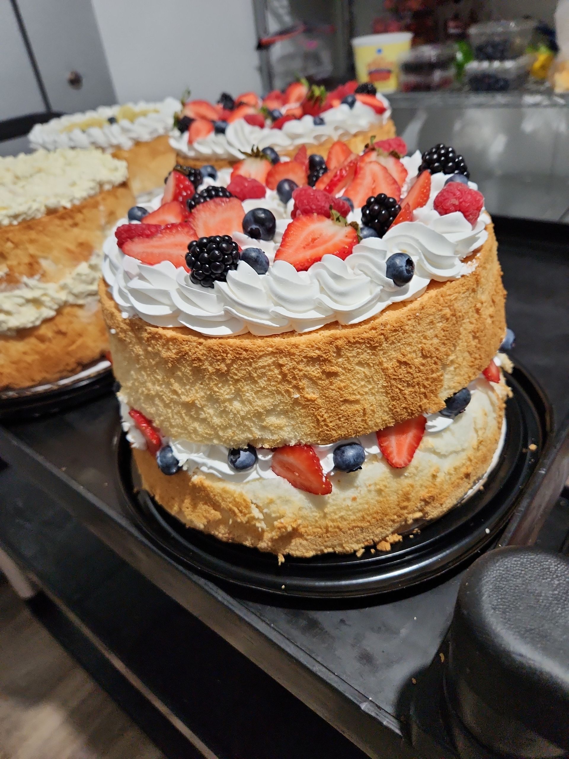 A cake with strawberries and blueberries on top of it