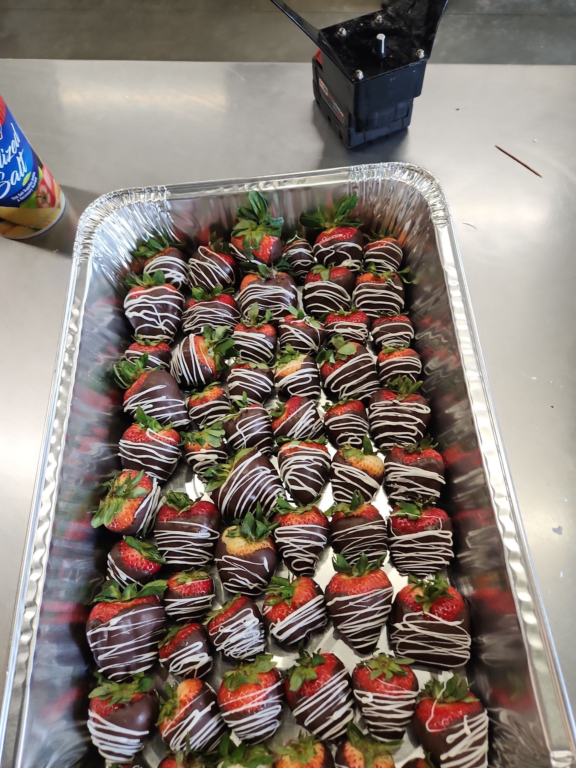 A tray of chocolate covered strawberries on a table.