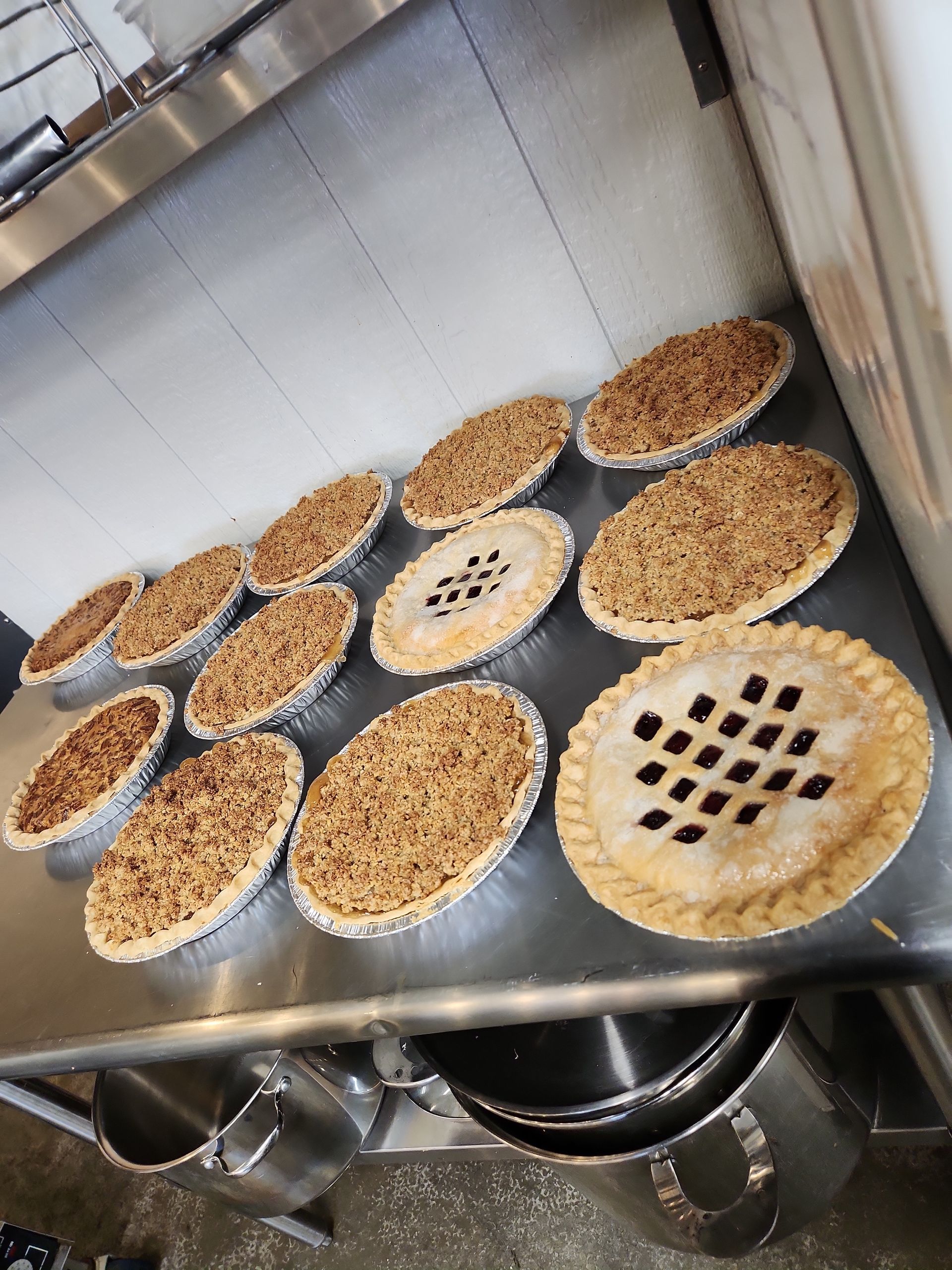 A bunch of pies are sitting on a counter in a kitchen.