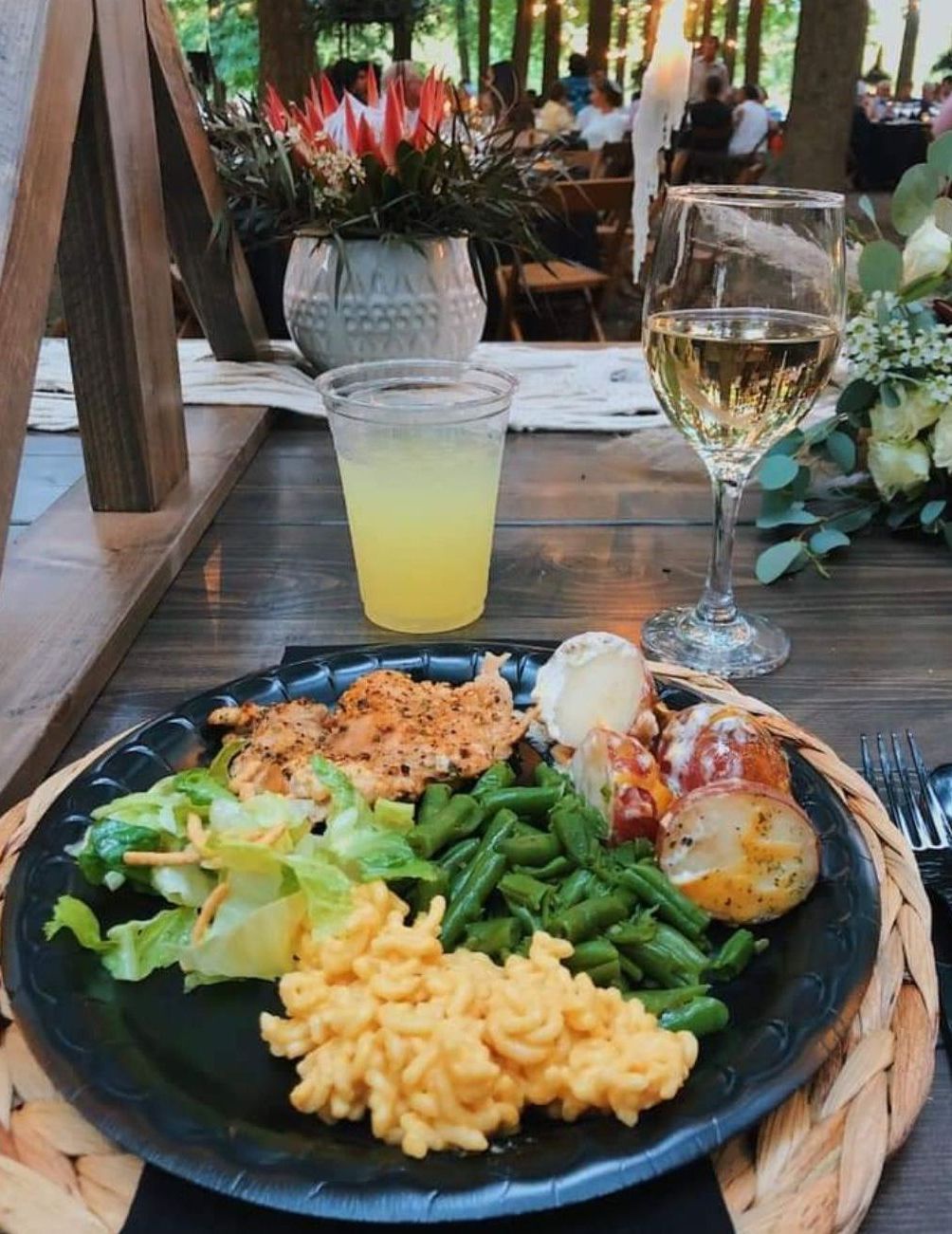 A plate of food and a glass of wine on a table.