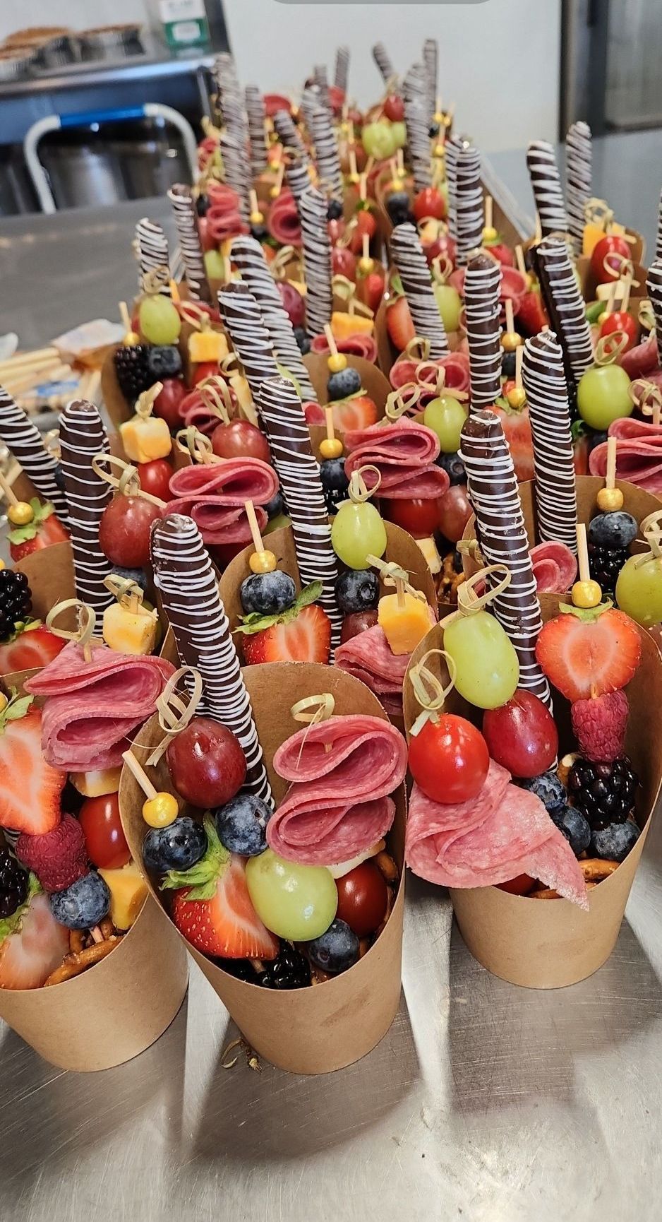 A bunch of cups filled with fruit and meat on a table.