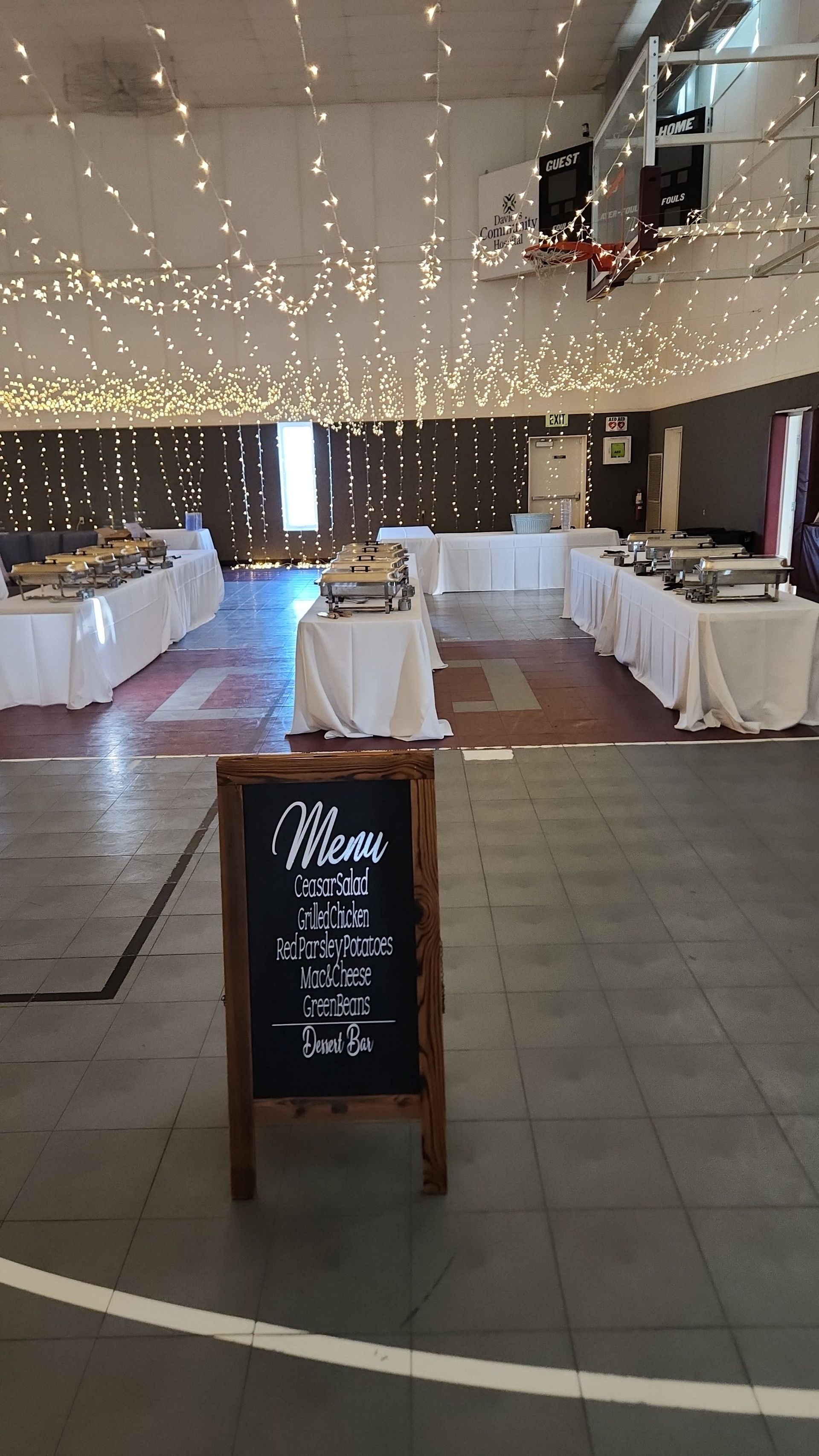 A large room with tables and a chalkboard in the middle of it.