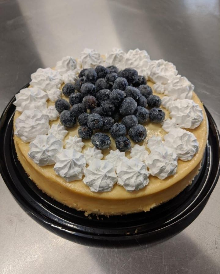 A cheesecake with whipped cream and blueberries on top.