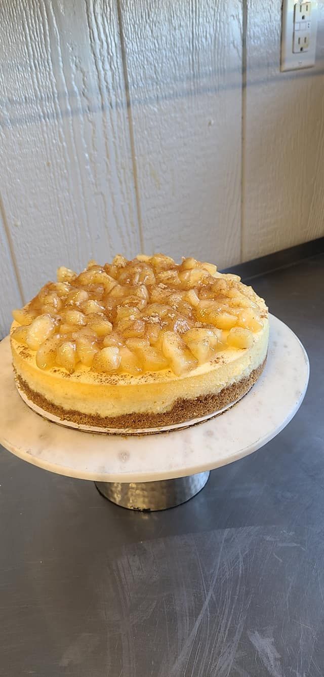 A cheesecake is sitting on top of a marble cake stand.