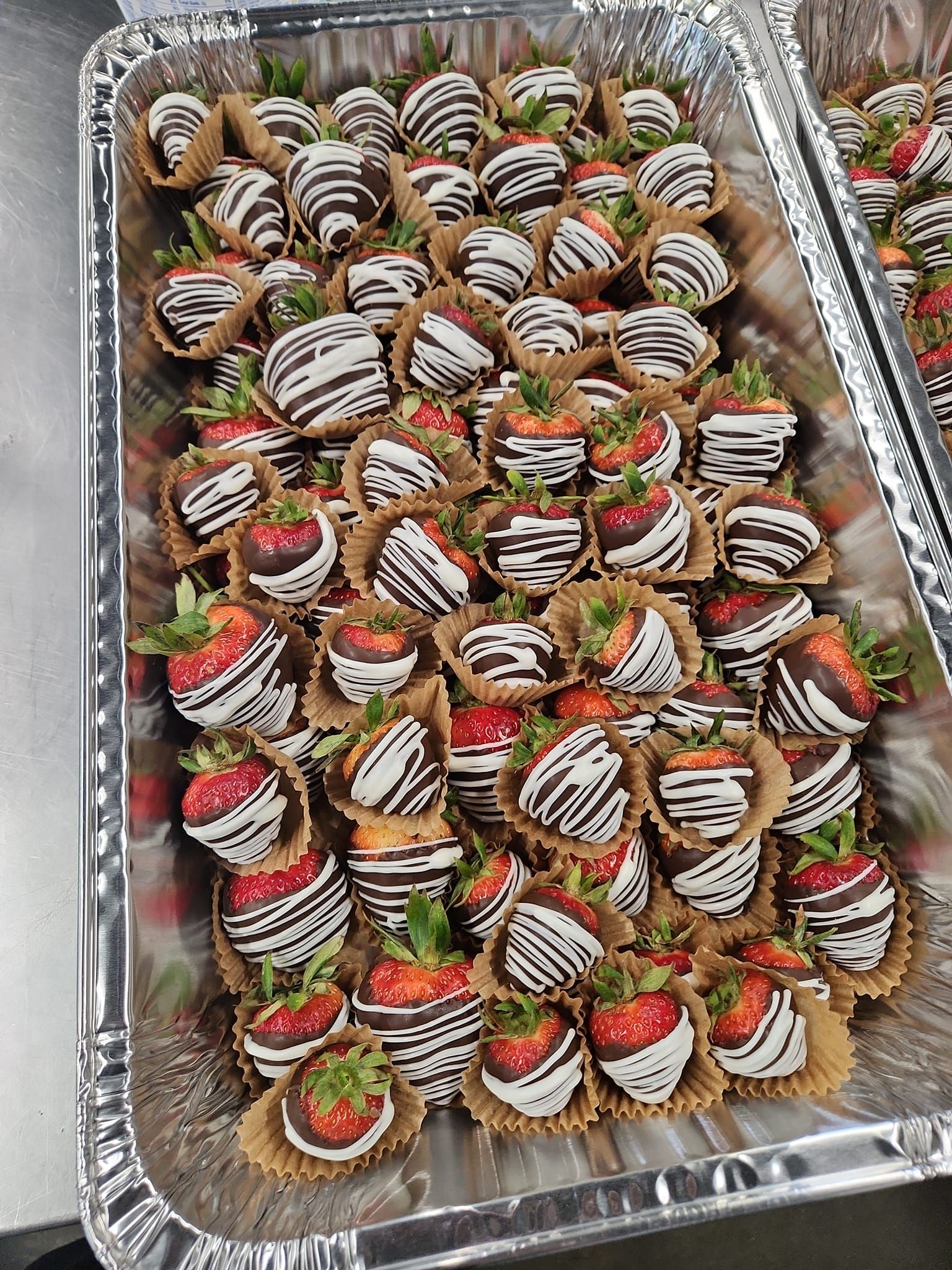 A tray of chocolate covered strawberries on a table.