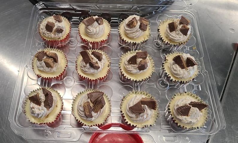 A plastic container filled with cupcakes on a table