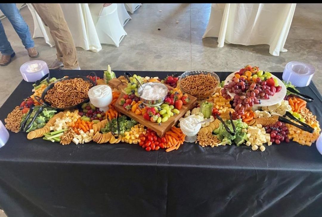 A long table topped with a variety of fruits and vegetables.