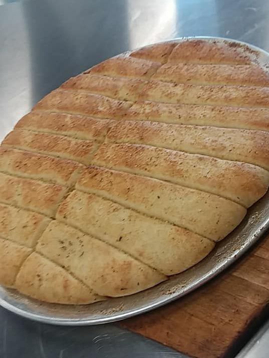 A loaf of garlic bread is sitting on top of a pan on a table.