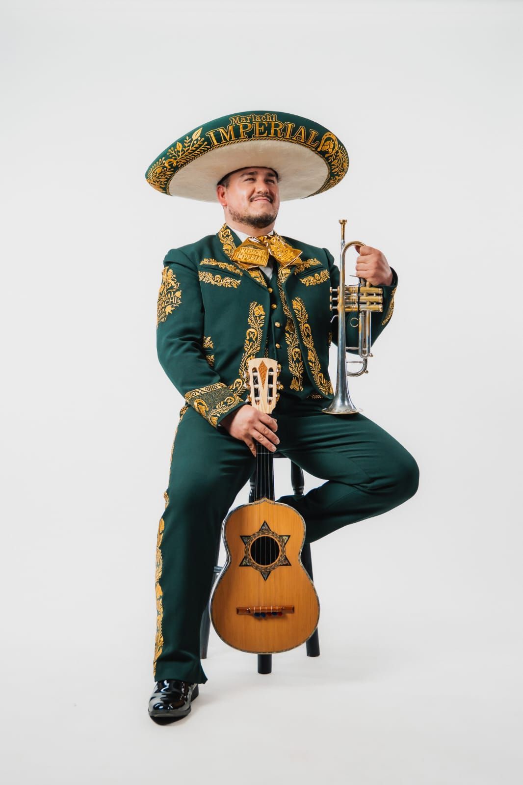 Cóctel amarillo con adorno de lima, maracuyá y un medidor de cobre sobre una barra de madera con luces de neón.