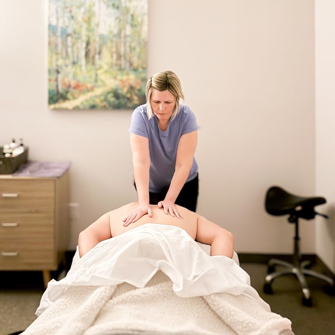 Woman in yoga pose, arched back over a bolster, arms extended, on a purple mat.