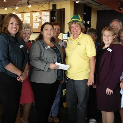 A group of people posing for a picture including a man in a yellow shirt