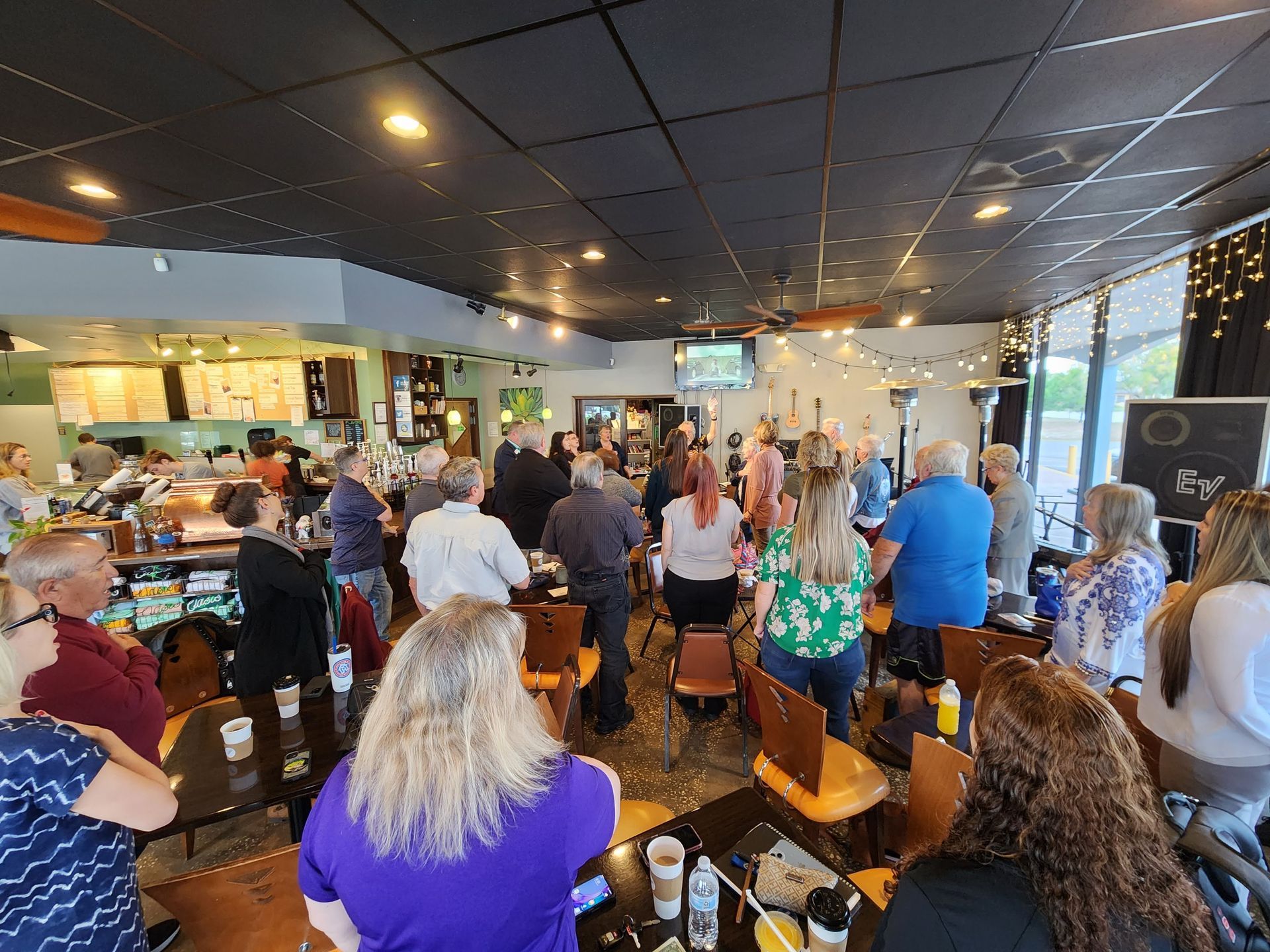 A large group of people are sitting at tables in a restaurant.