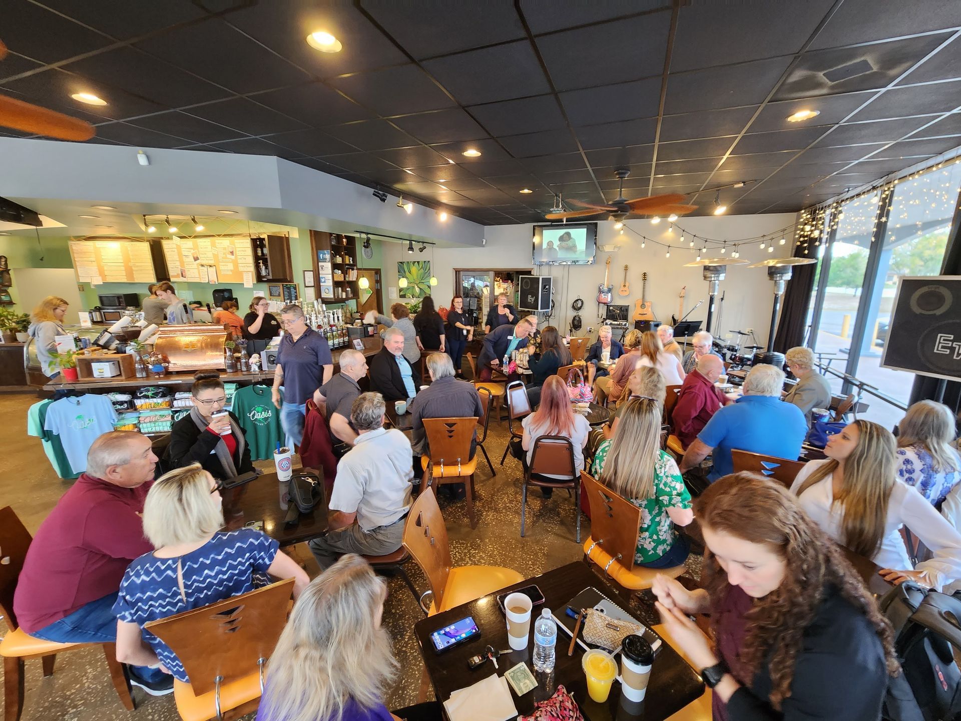 A large group of people are sitting at tables in a restaurant.