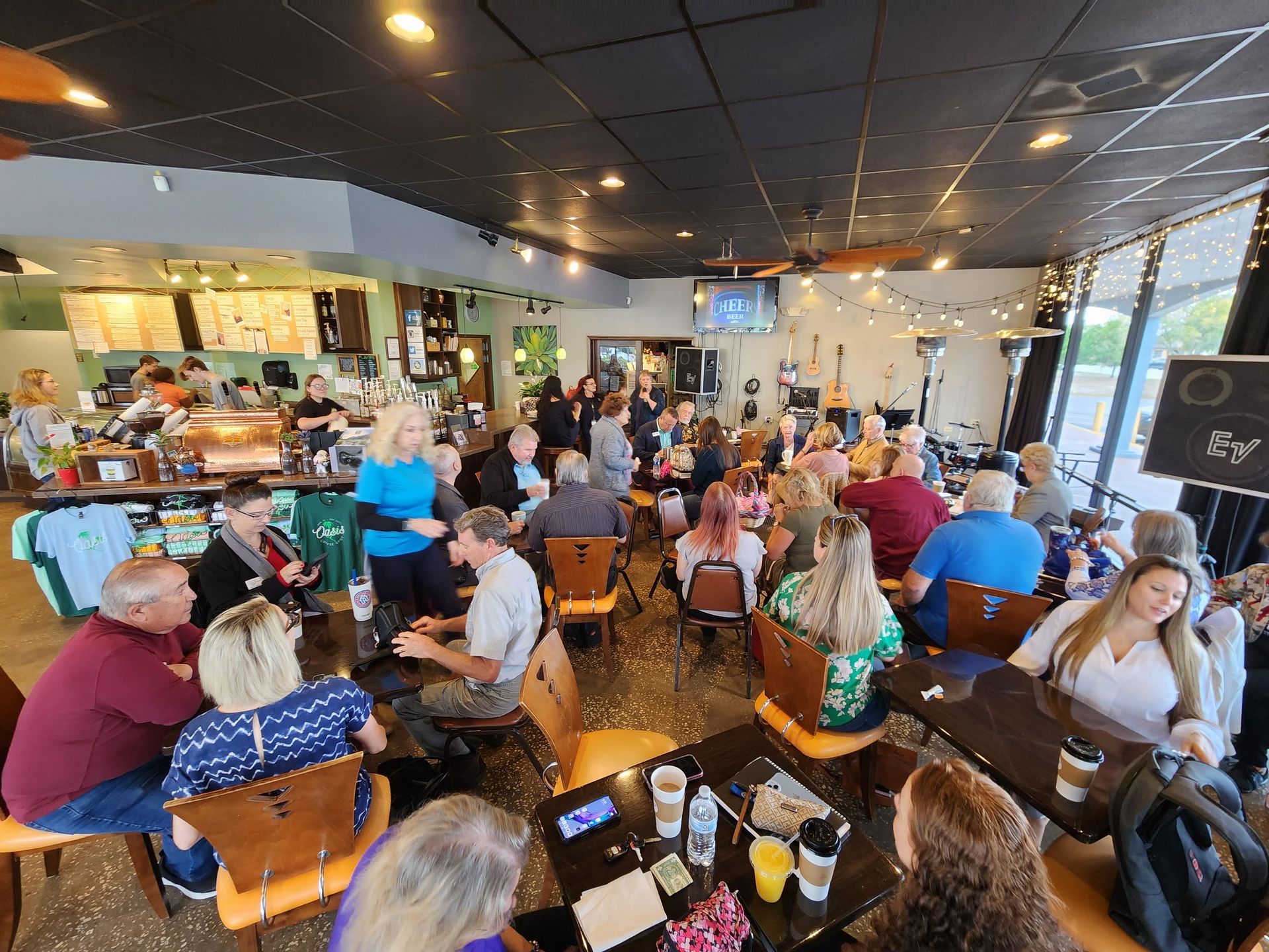 A large group of people are sitting at tables in a restaurant.