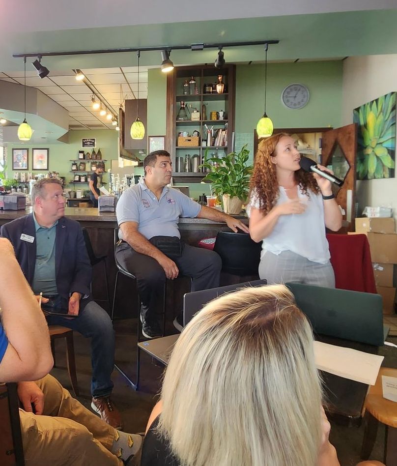 A woman singing into a microphone in front of a group of people
