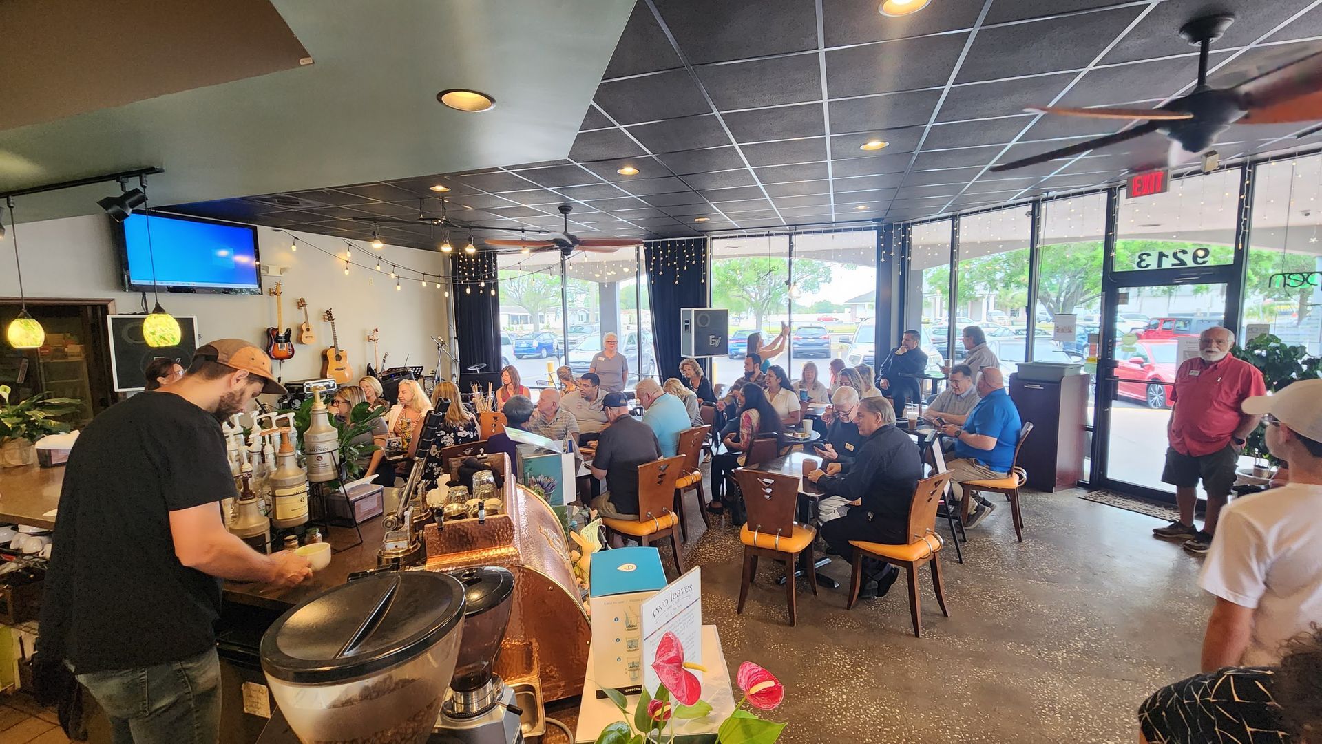 A group of people are sitting at tables in a restaurant.