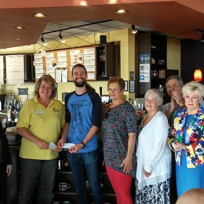 A group of people are posing for a picture in a restaurant