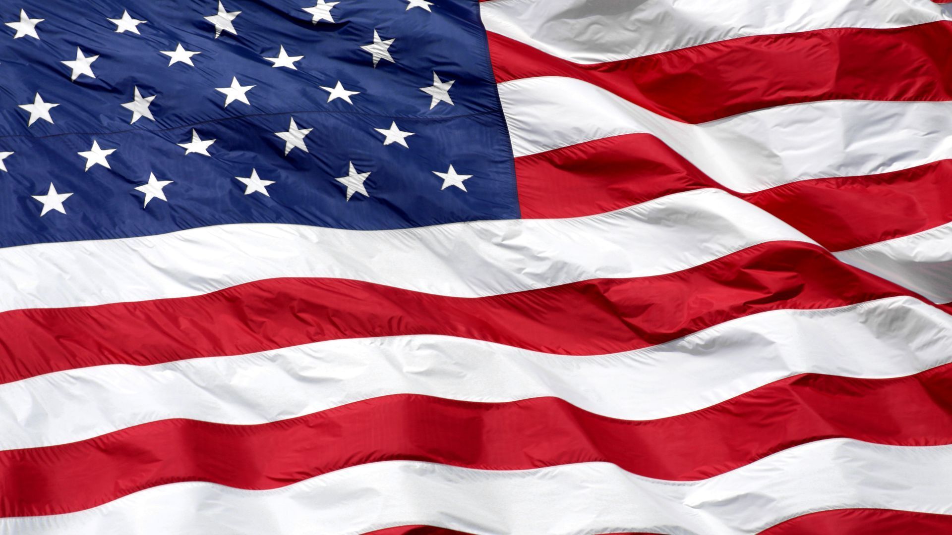 A close up of an american flag waving in the wind