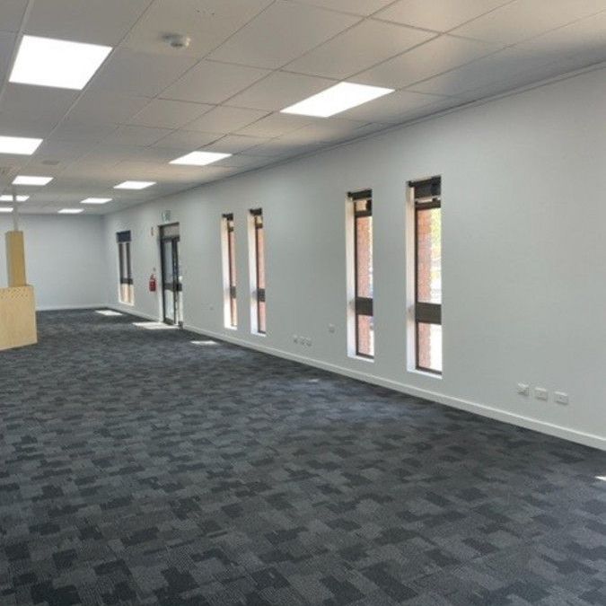 A large empty room with a carpeted floor and white walls