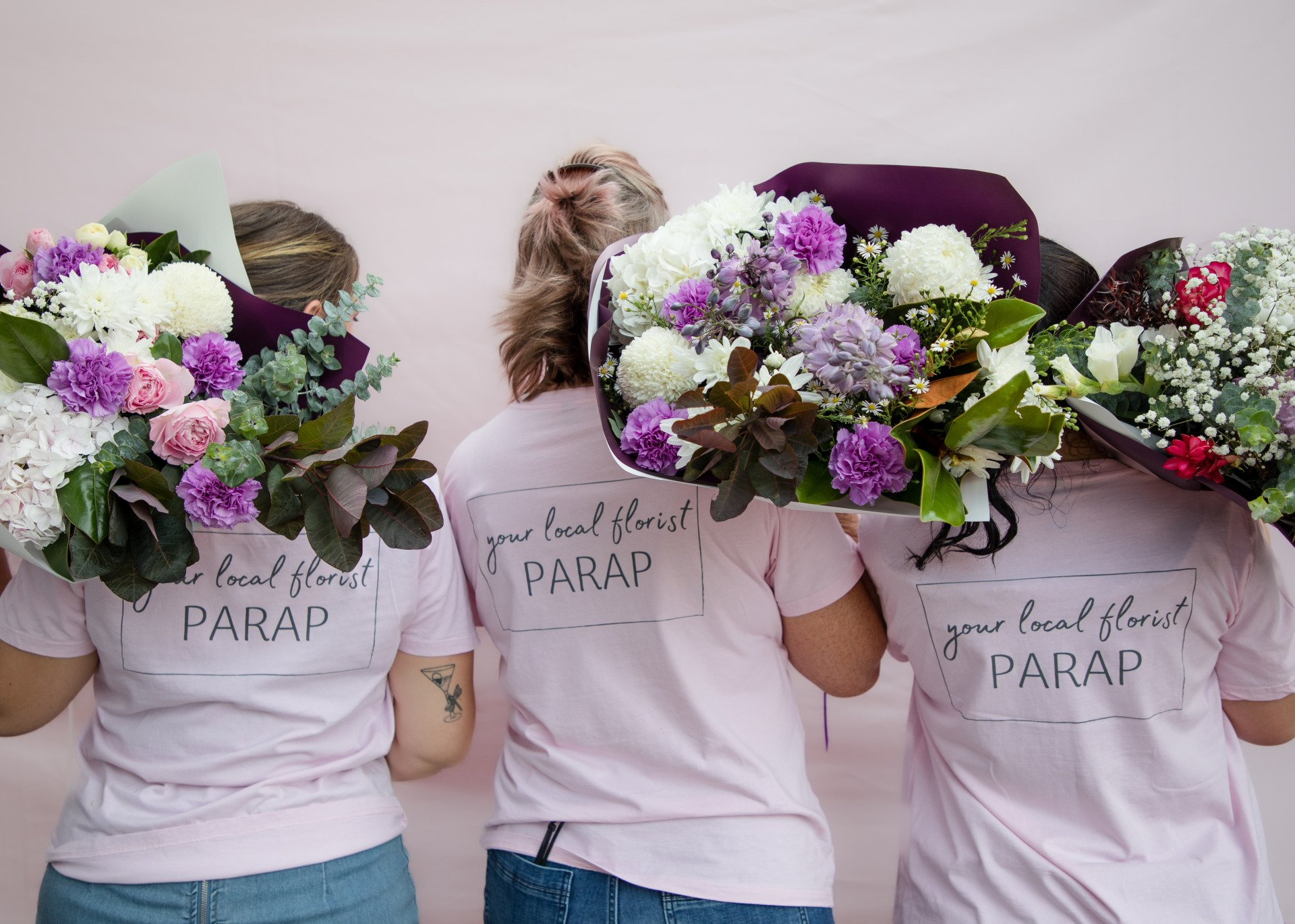 Darwin flower shop team showcasing vibrant purple blooms.
