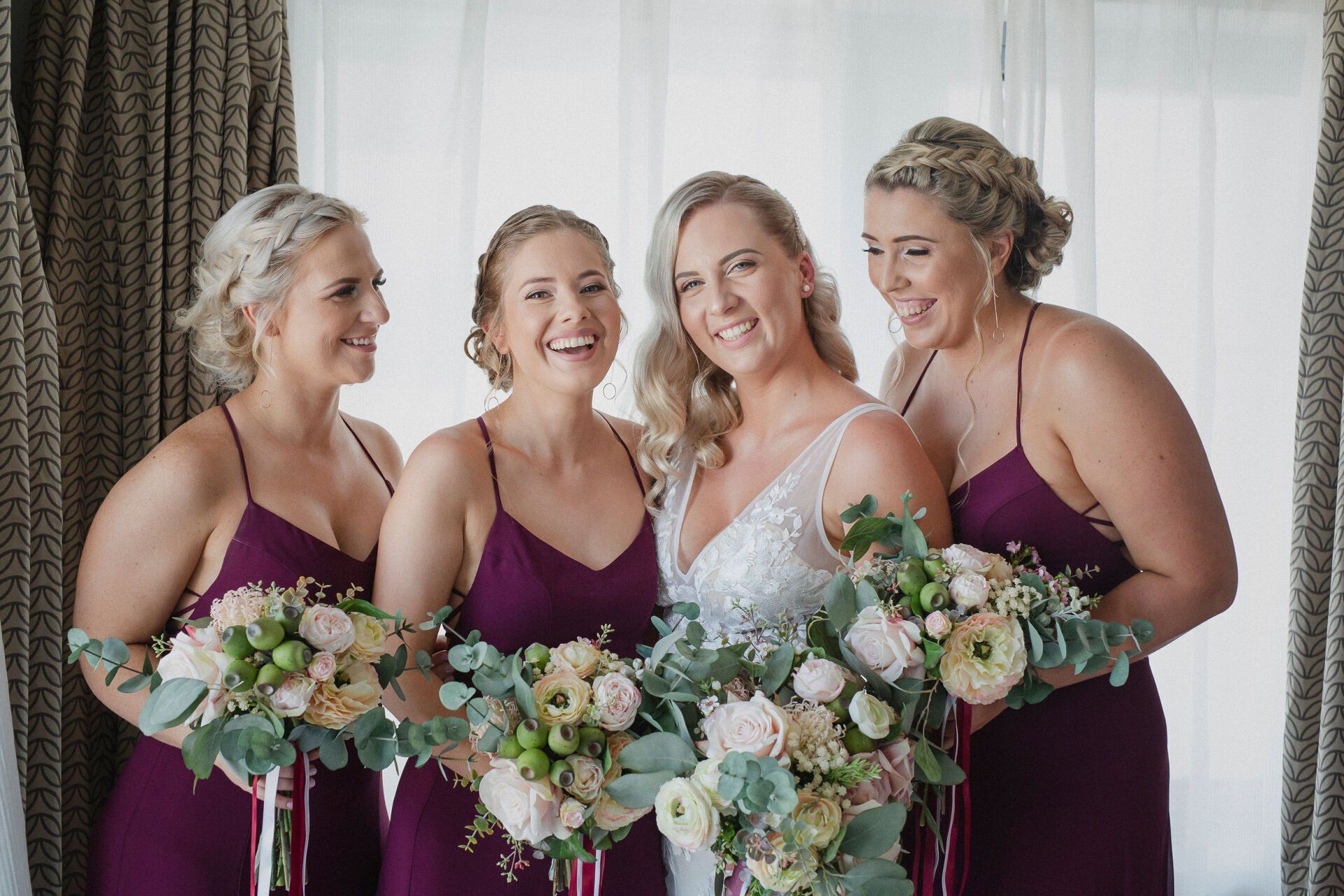 oyful bridesmaids at a Darwin wedding, surrounded by exquisite floral in hands