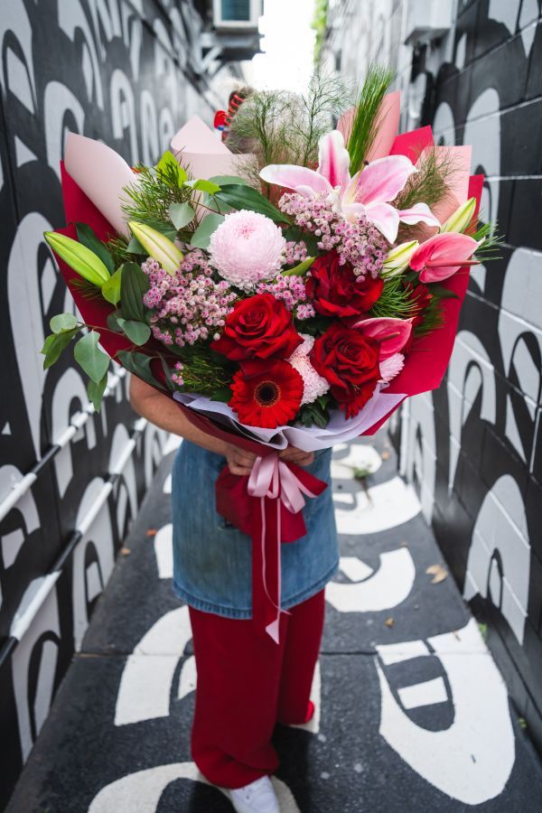 Joyful Darwin shop team with purple flowers, embodying happiness and unity.