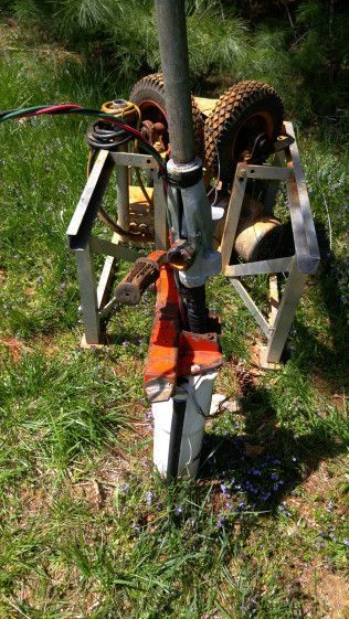 A lawn mower is sitting on top of a ladder in the grass.