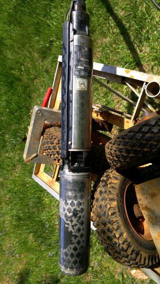 A water pump is sitting on top of a tire on a trailer.