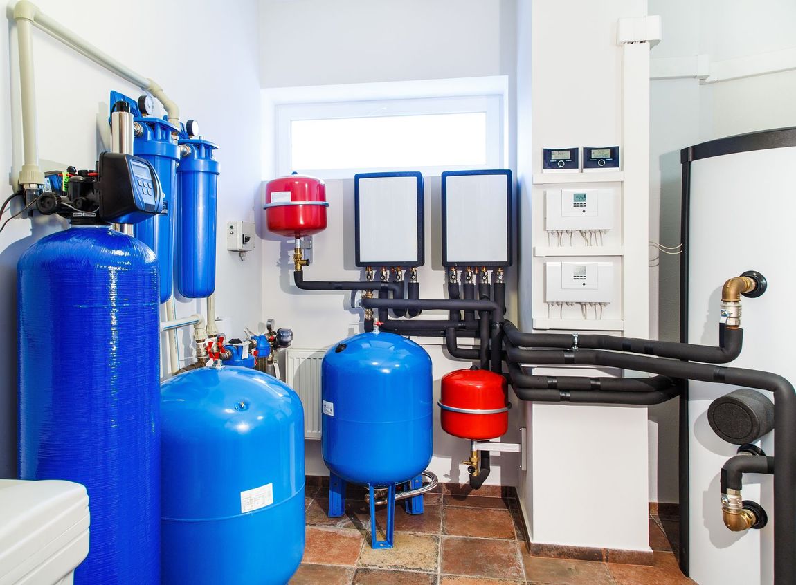 A room with a lot of blue tanks and pipes.