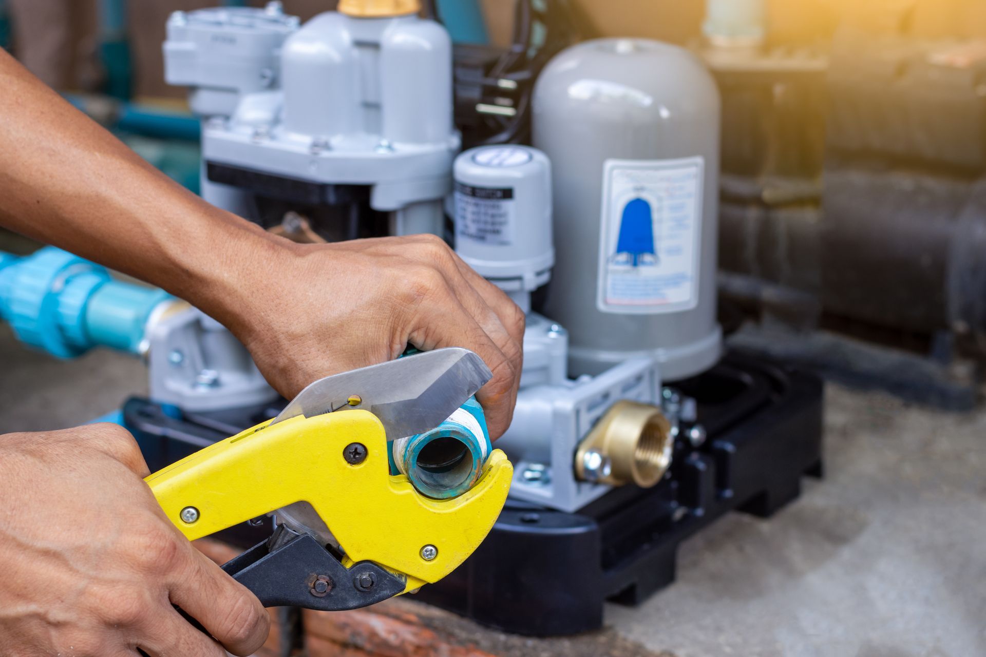 A man is working on a water pump with a pair of pliers.